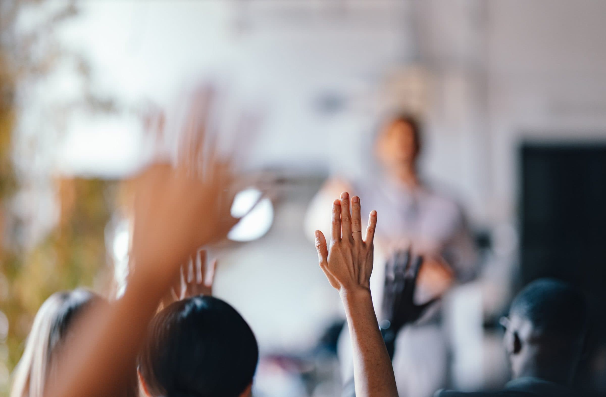 Publiek met opgestoken handen tijdens een sessie